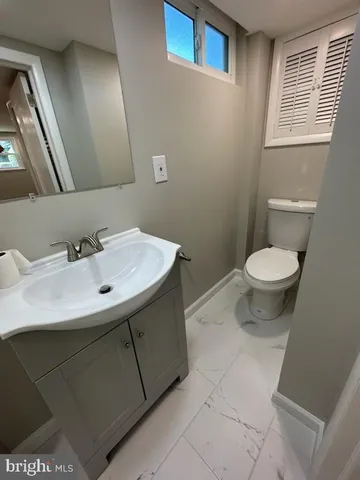 a bathroom with a sink toilet and a mirror