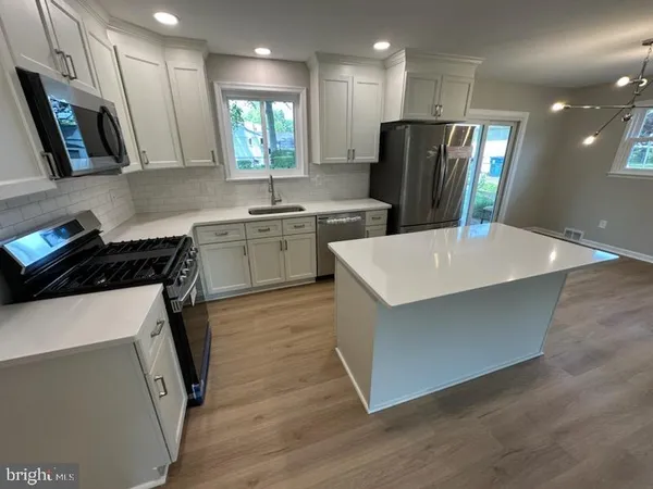 a kitchen with a refrigerator sink and wooden cabinets