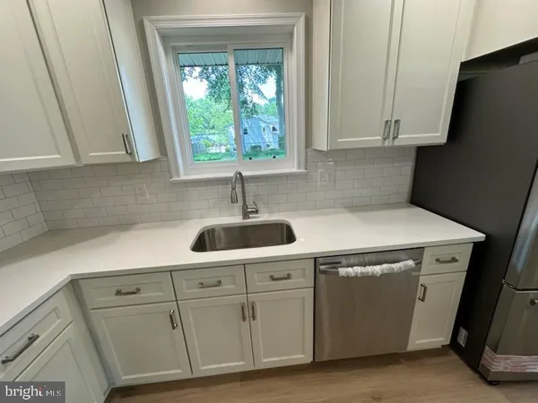 a kitchen with white cabinets and white appliances