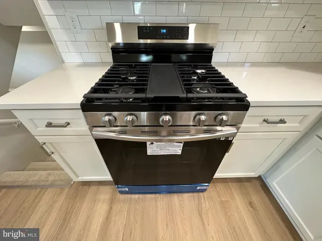 a stove top oven sitting inside of a kitchen
