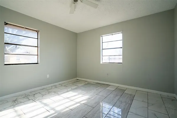 a view of a room with a ceiling fan and window