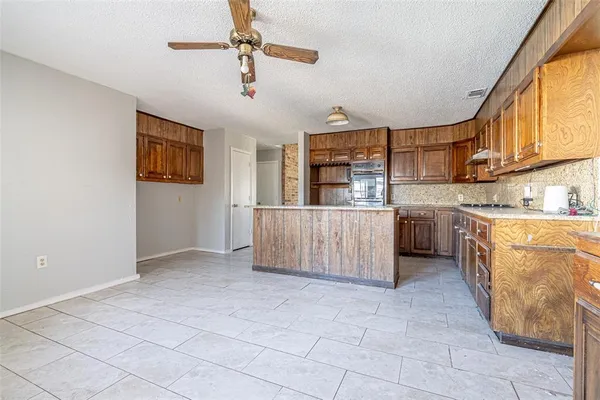 a kitchen with stainless steel appliances a sink window and cabinets
