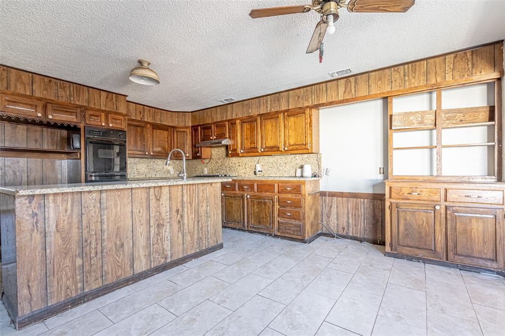 601 Henry Street Dublin, TX 76446 - Photo 9 of 40 a kitchen with stainless steel appliances a sink window and cabinets