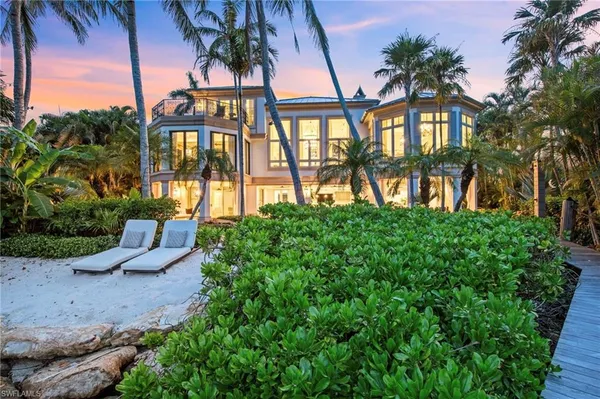a view of a house with a yard and potted plants