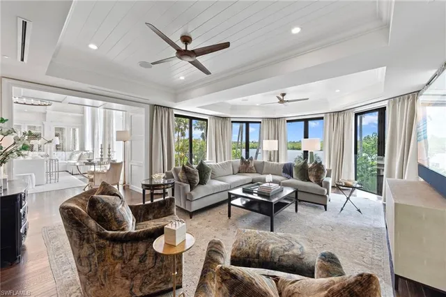 a living room with furniture ceiling fan and a large window