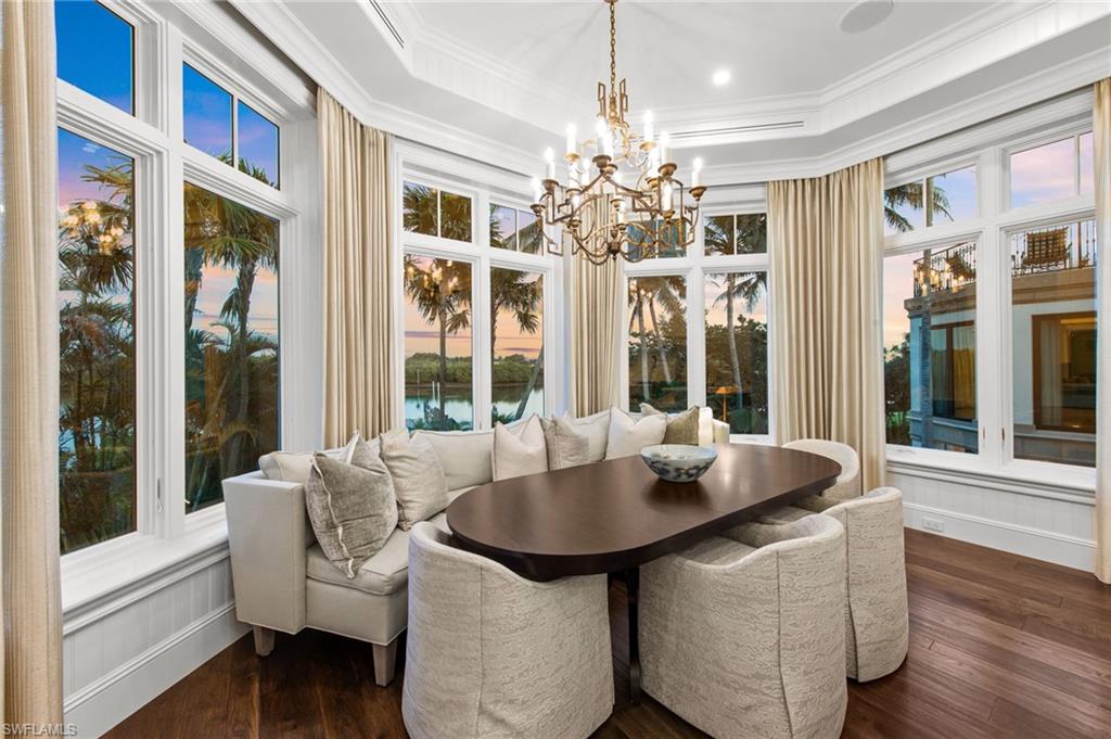 3675 Gordon Drive Naples, FL 34102 - Photo 18 of 50 a view of a dining room with furniture wooden floor and chandelier