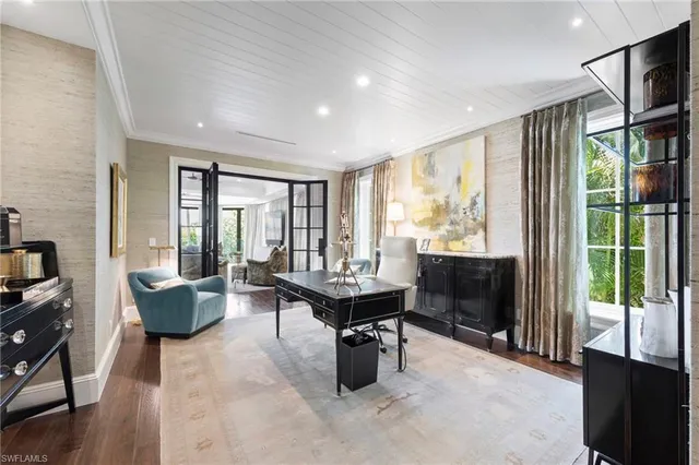 a bedroom with a bed a chandelier and a dresser