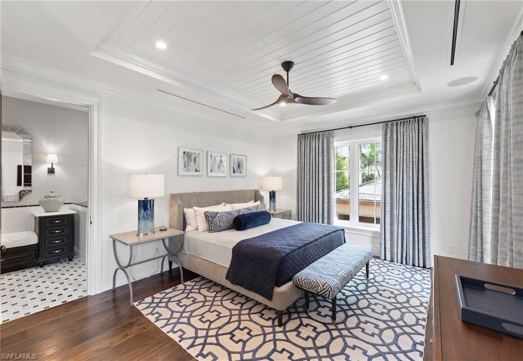 3675 Gordon Drive Naples, FL 34102 - Photo 28 of 50 a bedroom with a large bed and a chandelier