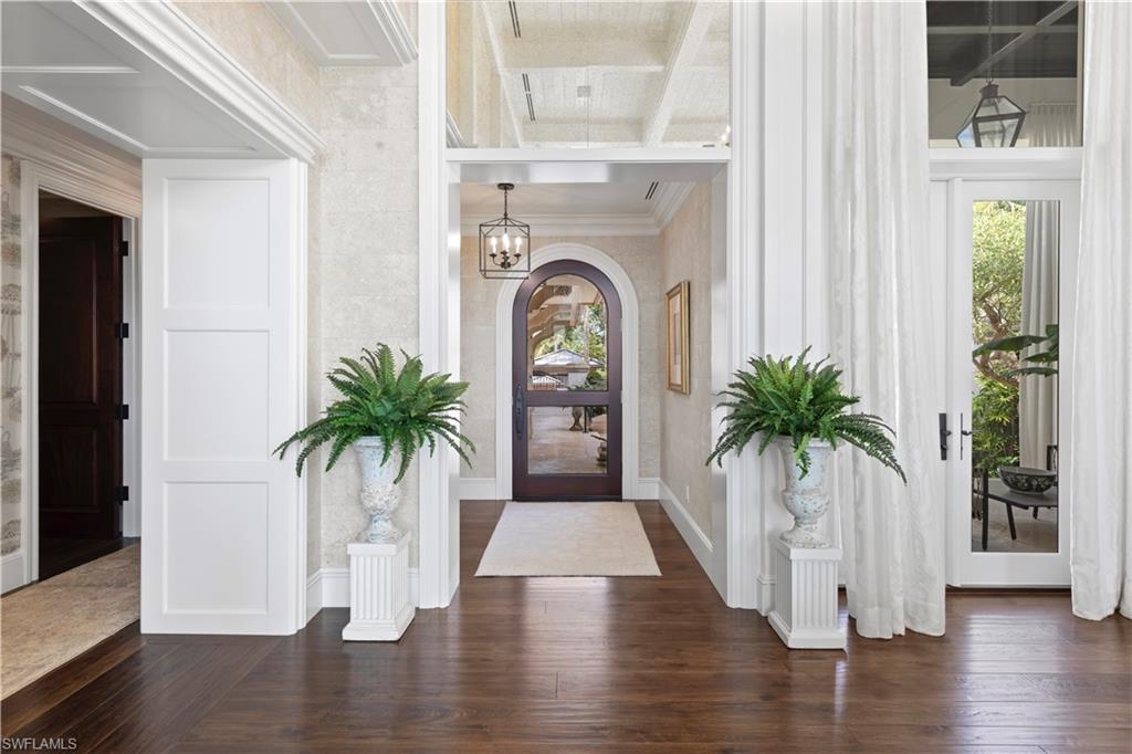 3675 Gordon Drive Naples, FL 34102 - Photo 32 of 50 a view of a hallway with potted plants and wooden floor