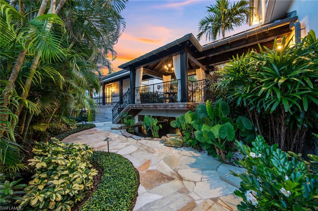 3675 Gordon Drive Naples, FL 34102 - Photo 41 of 50 a front view of a house with a yard and a garden