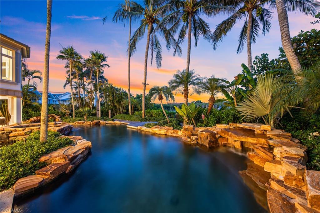 3675 Gordon Drive Naples, FL 34102 - Photo 43 of 50 a view of swimming pool with a table and chairs