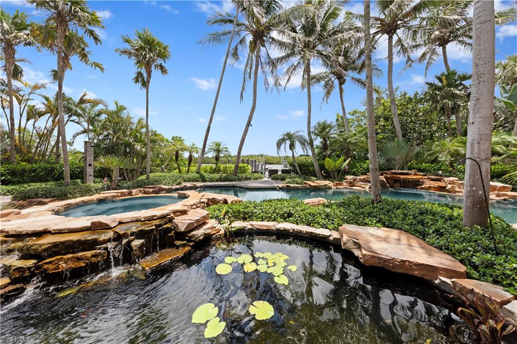 3675 Gordon Drive Naples, FL 34102 - Photo 45 of 50 a view of a swimming pool with a patio and a yard
