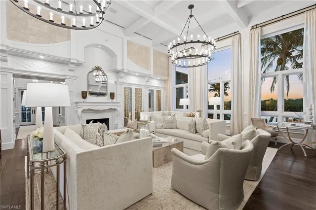 a large white kitchen with kitchen island lots of counter space wooden floor and stainless steel appliances