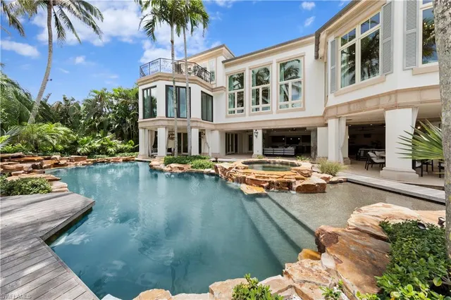 a spacious bedroom with a bed a table and large window