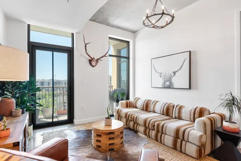 a living room with furniture potted plant and a large window