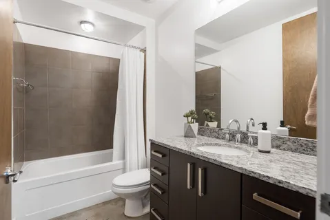 a bathroom with a granite countertop sink toilet and shower