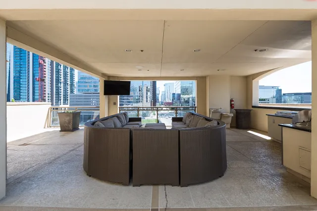 a living room with couches a flat tv screen and a fireplace