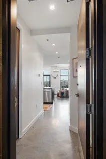 a view of a hallway with a livingroom and furniture
