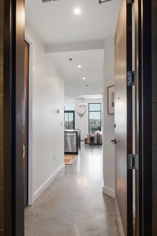 a view of a hallway with a livingroom and furniture