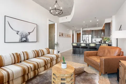 a living room with furniture kitchen and a chandelier
