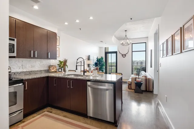 a kitchen with stainless steel appliances granite countertop a sink and wooden cabinets