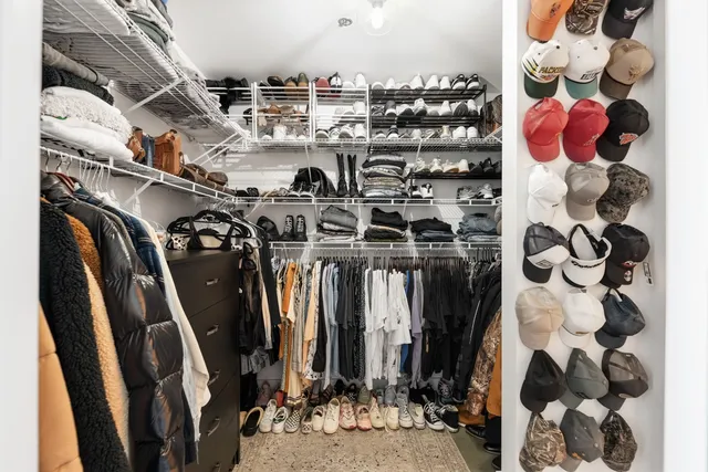 a view of walk in closet with clothes and shoes