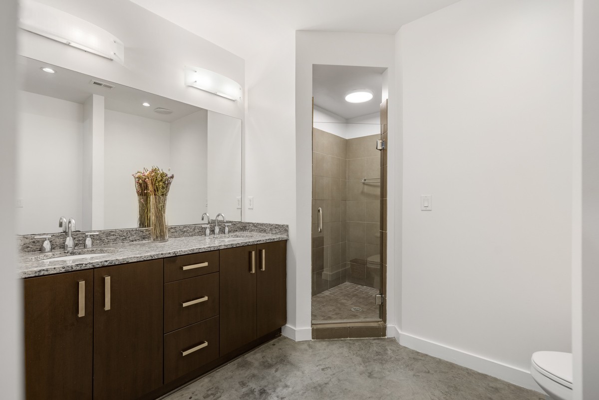 1510 Demonbreun Street, Unit 701 Nashville, TN 37203 - Photo 8 of 22 a bathroom with a granite countertop sink a toilet and mirror