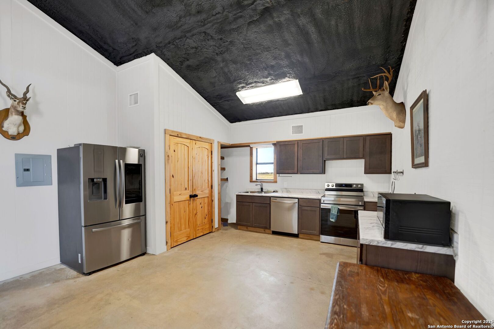 722 County Road 424 Hondo, TX 78861 - Photo 35 of 45 a large kitchen with stainless steel appliances granite countertop a stove refrigerator and microwave