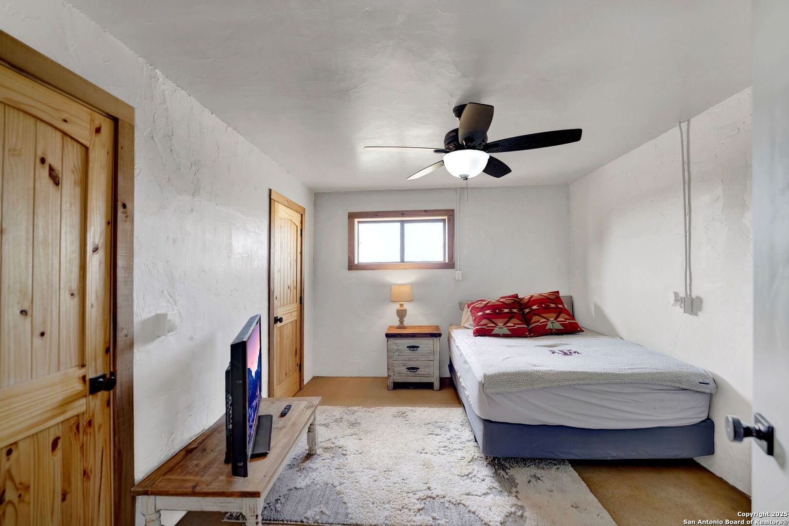 722 County Road 424 Hondo, TX 78861 - Photo 37 of 45 a bedroom with a bed and a chandelier