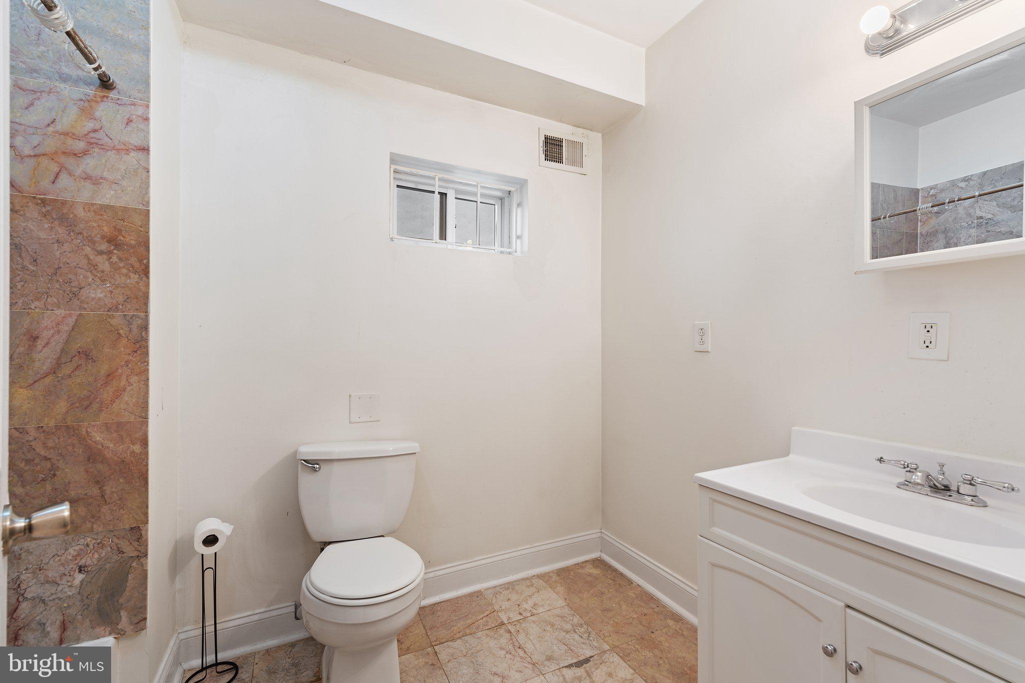 1729 Fontain Street, Unit 1 Philadelphia, PA 19121 - Photo 18 of 25 a bathroom with a sink a toilet and a mirror