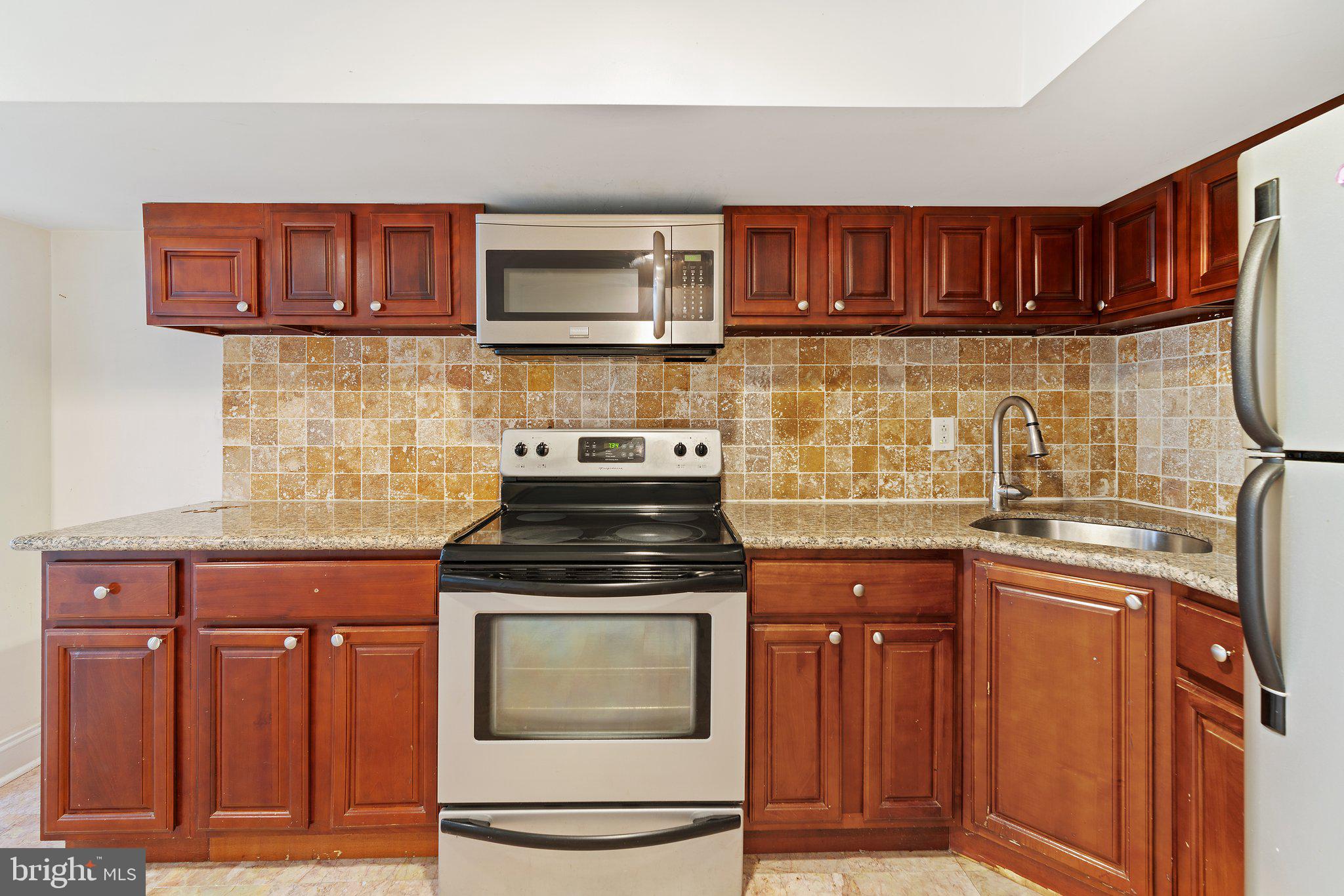 1729 Fontain Street, Unit 1 Philadelphia, PA 19121 - Photo 4 of 25 a kitchen with stainless steel appliances granite countertop a stove and a microwave
