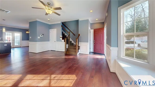 a view of an entryway with wooden floors and stairs