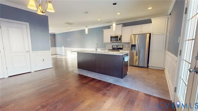 a kitchen with stainless steel appliances a refrigerator and wooden floor