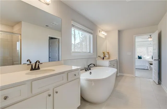 a bathroom with a white tub a sink and a window