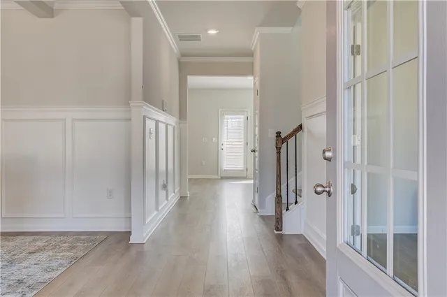 a view of a hallway with wooden floor and staircase
