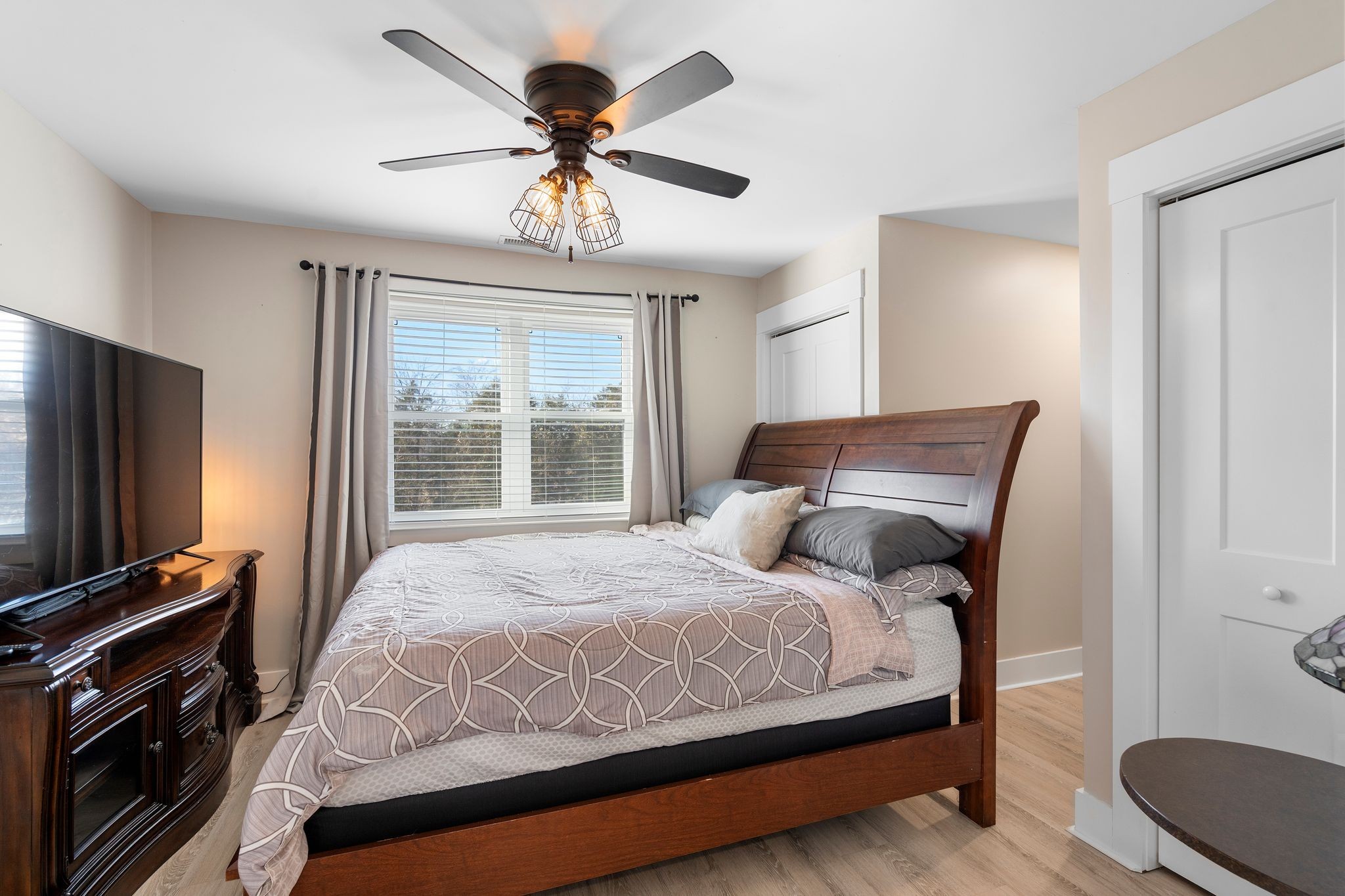 5650 Sledge Road Christiana, TN 37037 - Photo 26 of 50 a bedroom with a large bed and a flat tv screen on a dresser