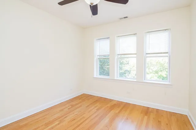 an empty room with a window and wooden floor