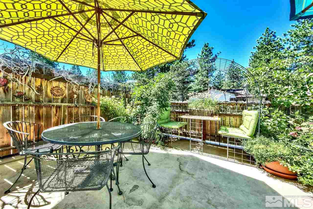 450 Mcfaul Way Zephyr Cove, NV 89448 - Photo 17 of 20 a backyard of a house with table and chairs under an umbrella