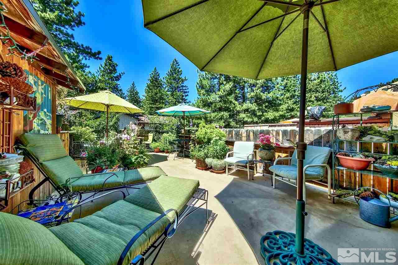 450 Mcfaul Way Zephyr Cove, NV 89448 - Photo 2 of 20 a view of a patio with chairs and table under an umbrella