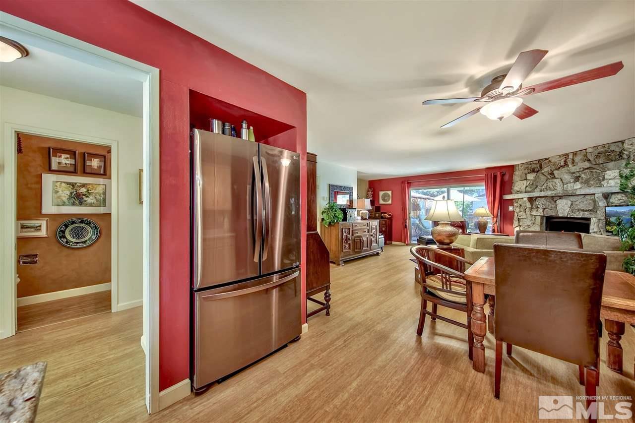 450 Mcfaul Way Zephyr Cove, NV 89448 - Photo 8 of 20 a kitchen with stainless steel appliances granite countertop a refrigerator a stove top oven a dining table and chairs with wooden floor