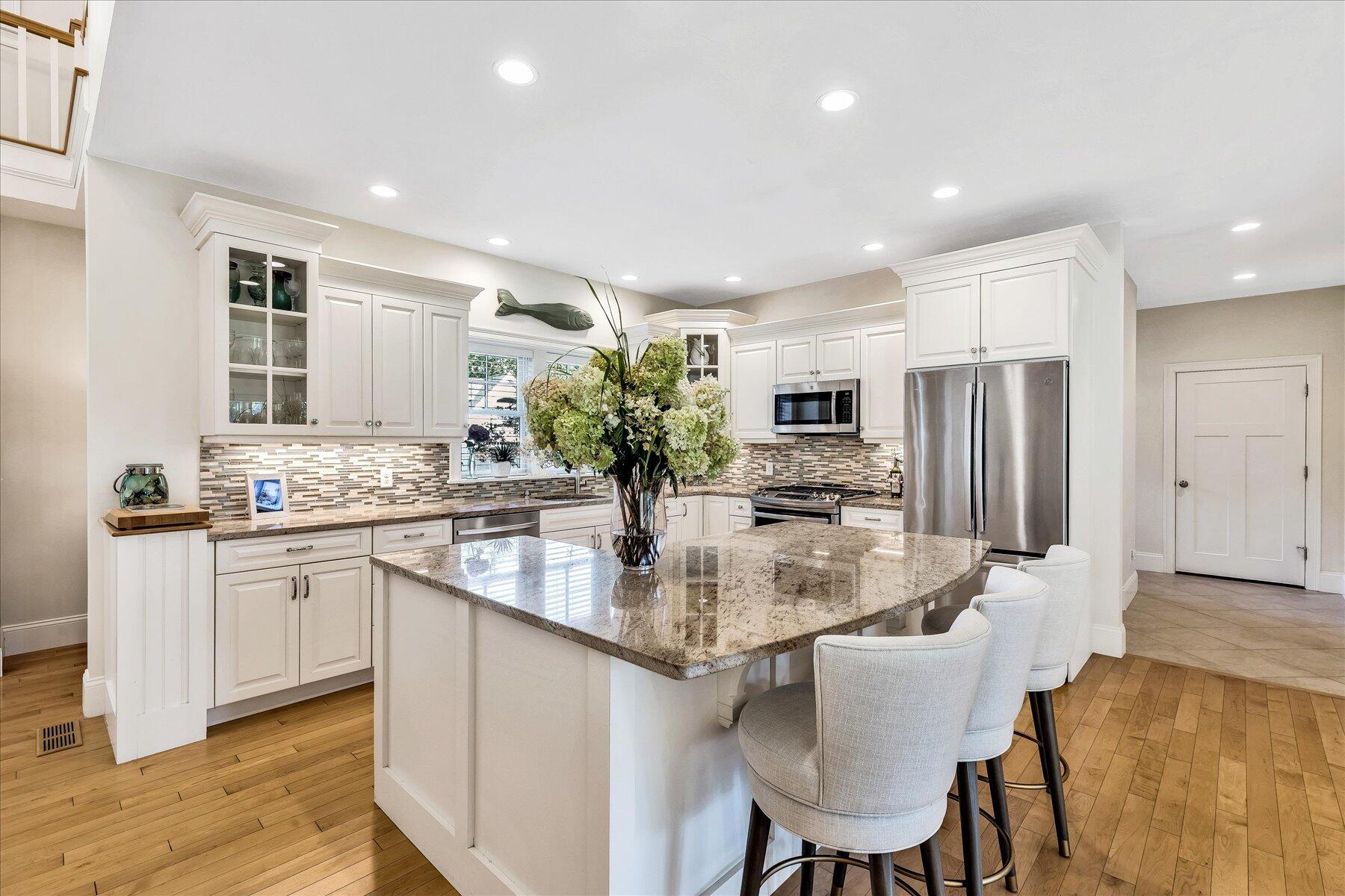 74 The Heights Mashpee, MA 02649 - Photo 9 of 34 a kitchen with kitchen island granite countertop a sink and white cabinets