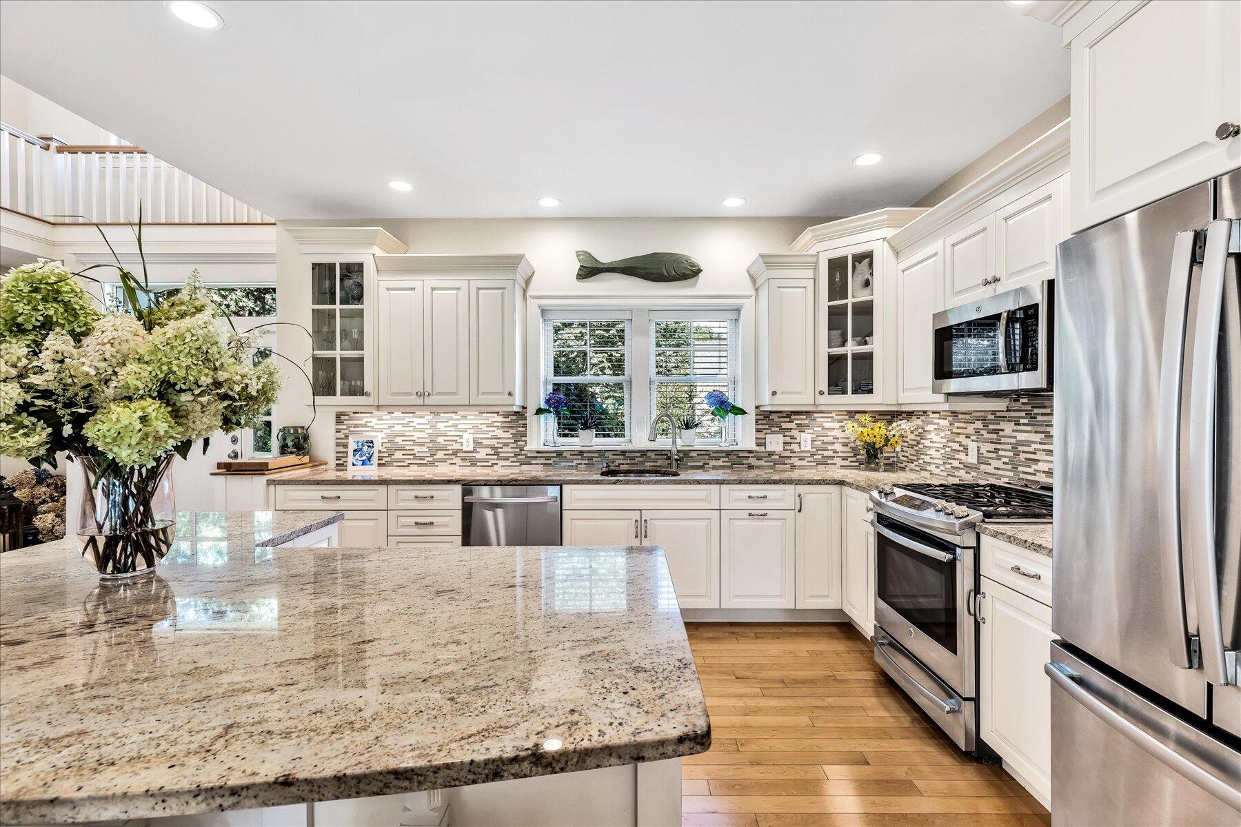 74 The Heights Mashpee, MA 02649 - Photo 10 of 34 a kitchen with kitchen island granite countertop a stove and cabinets