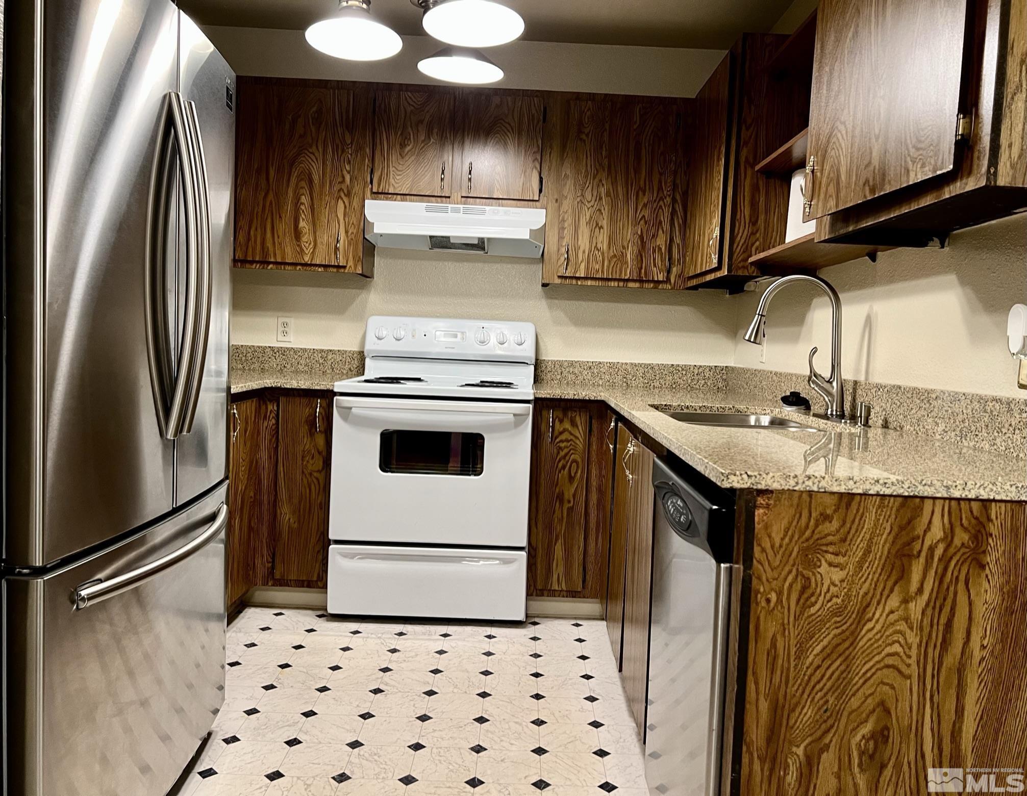 2090 Highview Court, Unit 1 Reno, NV 89512 - Photo 5 of 18 a kitchen with stainless steel appliances a refrigerator a sink and wooden cabinets