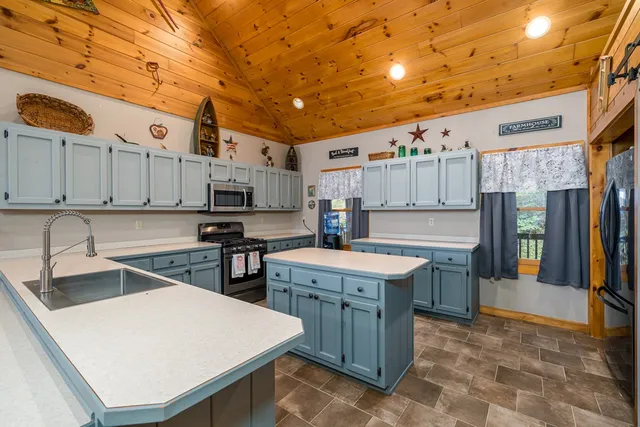a kitchen with stainless steel appliances granite countertop a sink a stove and a refrigerator