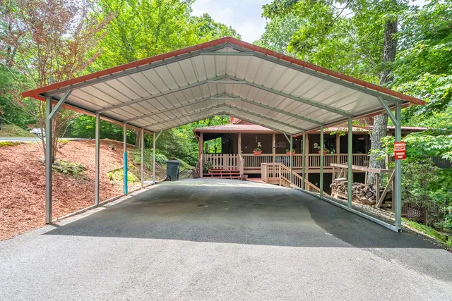 a view of a patio with table and chairs under an umbrella with a large tree