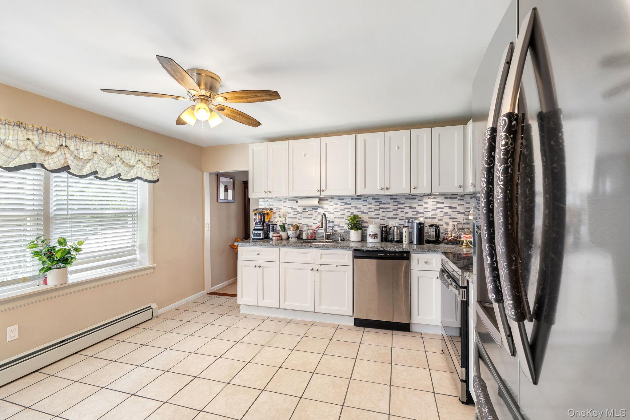 6 Farmstead Road New Windsor, NY 12553 - Photo 13 of 32 Kitchen with stainless steel appliances, white cabinets, backsplash, dark stone countertops, and light tile patterned floors