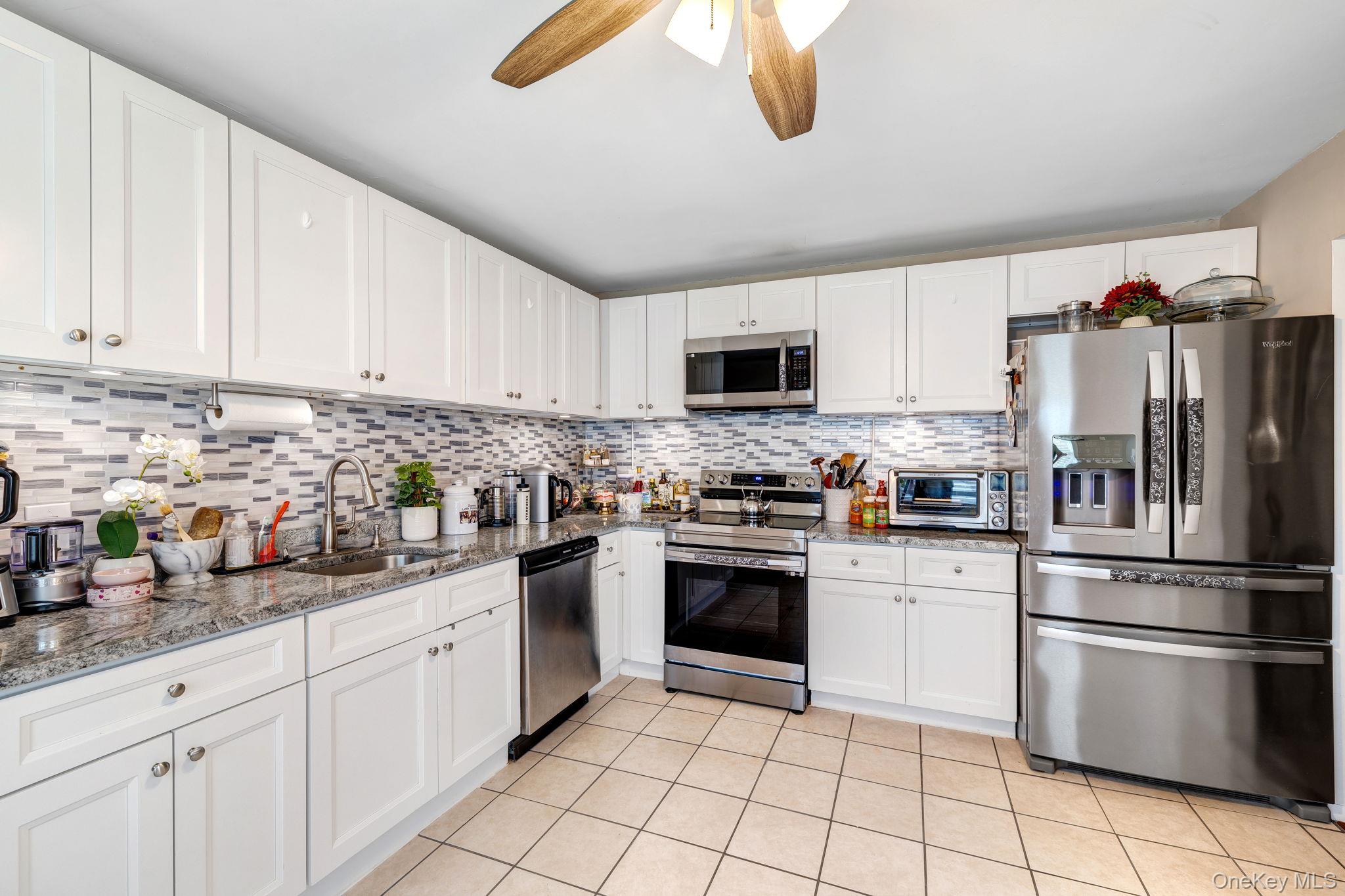 6 Farmstead Road New Windsor, NY 12553 - Photo 14 of 32 Kitchen with appliances with stainless steel finishes, white cabinets, light stone counters, light tile patterned flooring, and ceiling fan