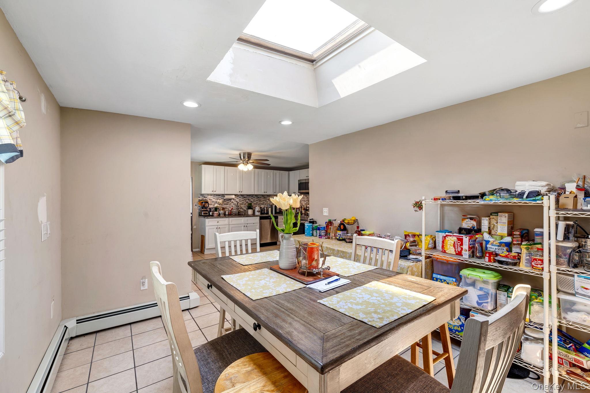 6 Farmstead Road New Windsor, NY 12553 - Photo 16 of 32 Dining space with light tile patterned floors, recessed lighting, a baseboard heating unit, a ceiling fan, and a skylight