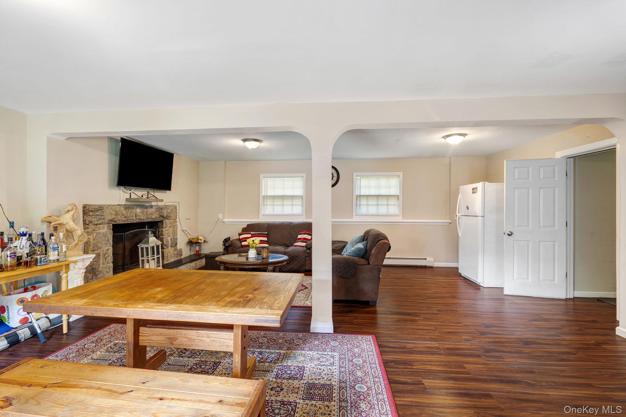 6 Farmstead Road New Windsor, NY 12553 - Photo 28 of 32 Living area featuring dark wood-style floors, a fireplace, baseboard heating, and arched walkways