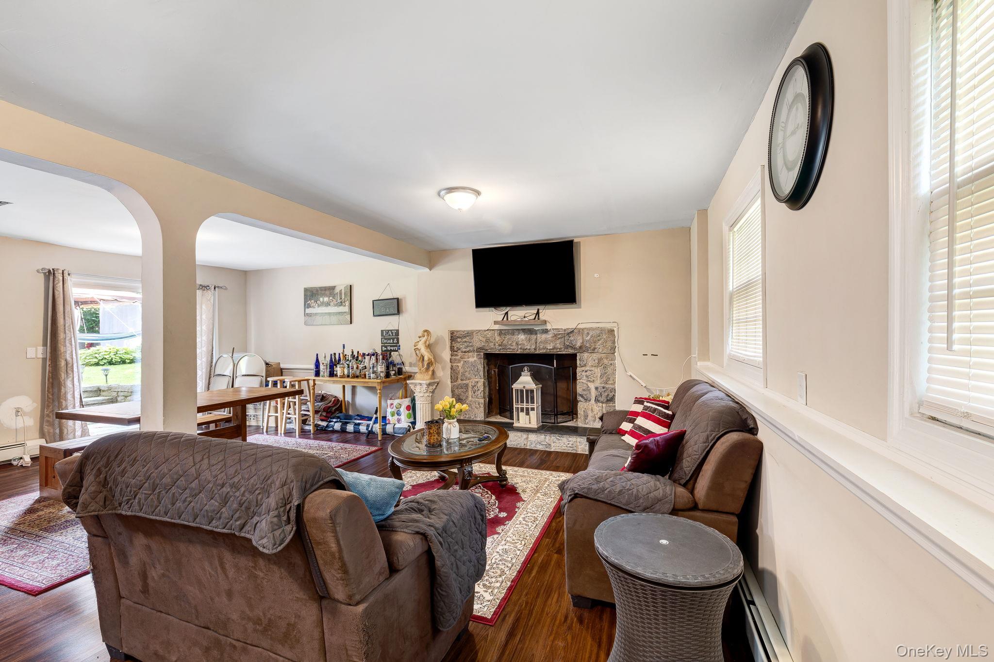 6 Farmstead Road New Windsor, NY 12553 - Photo 29 of 32 Living area featuring arched walkways, wood finished floors, and a stone fireplace